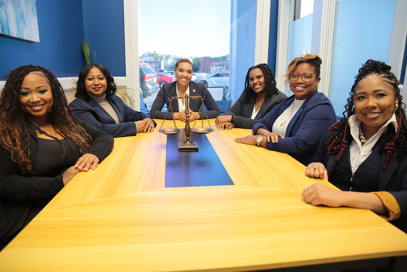 The Elizabeth Hunter & Associates team seated around a conference table with scales of justice